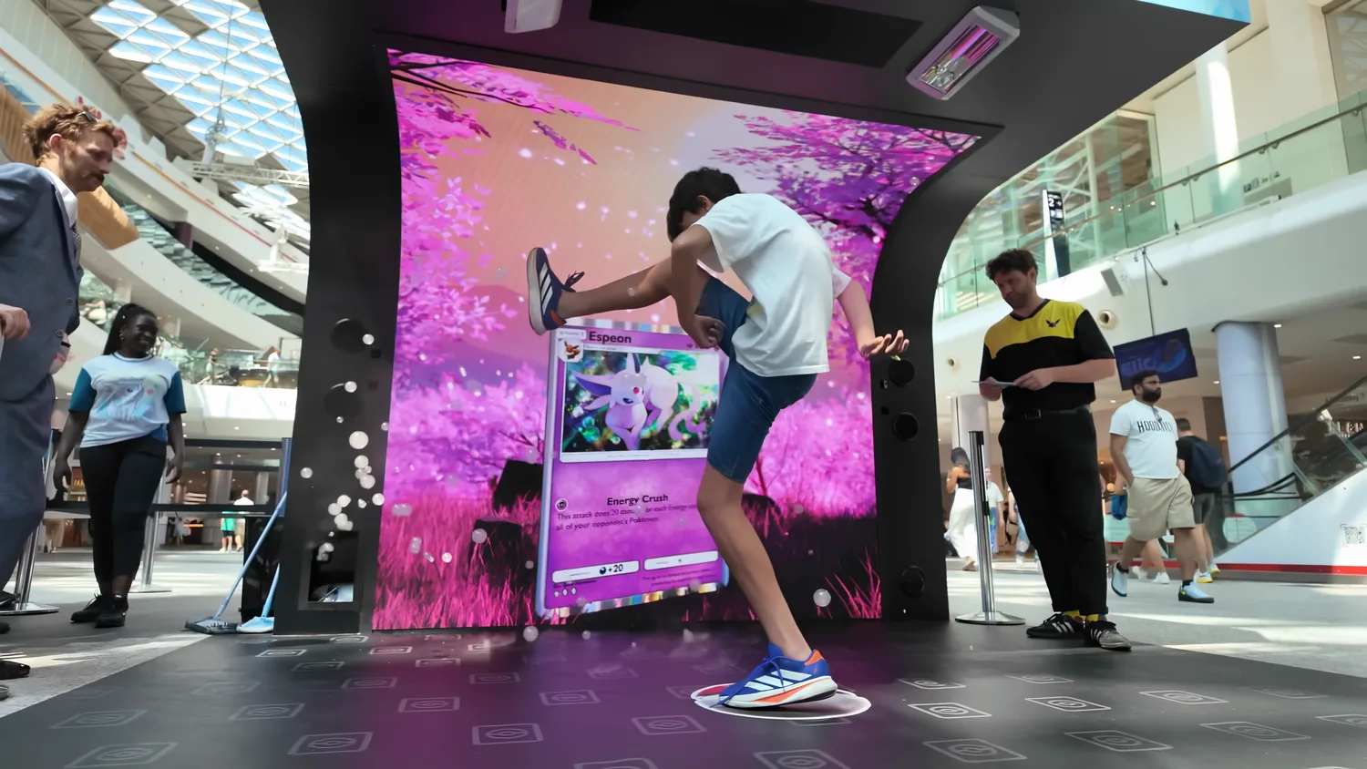 A boy playing on an interactive floor and wall installation in a shopping centre