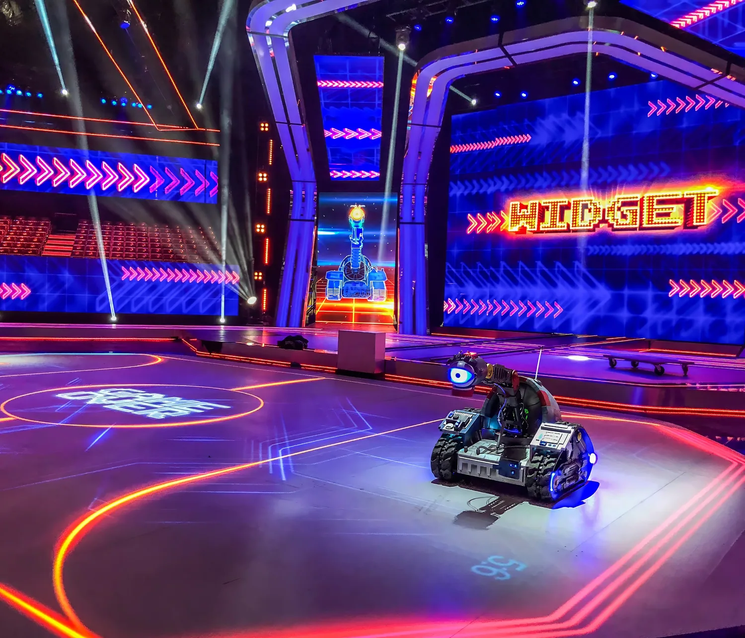 A television studio floor with screens, lighting and a robot on the playing surface